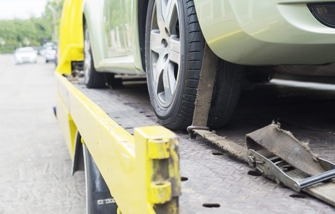 car transporter breakdown lorry during working using locked belt transport other green car for repairing at car center in a bangkok city thailand
